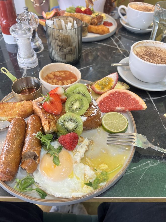 Laid table for two with a brunch plate, fresh fruit and two cappuccinos